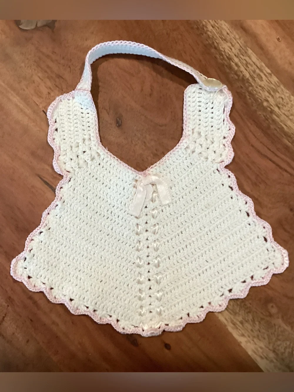 Vintage hand-made crocheted baby bib with pink scalloped lace look trim. 1950s